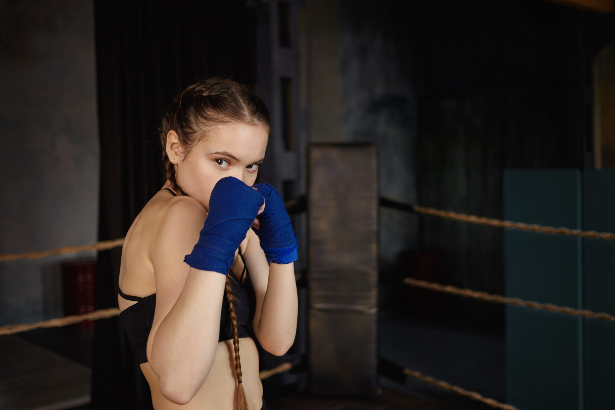 Młoda dziewczyna ćwiczy techniki na obóz krav maga, energiczna kobieta trenuje na obóz krav maga, trening samoobrony na obóz krav maga dla początkujących